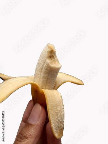 Hand holding peeled yellow fresh banana