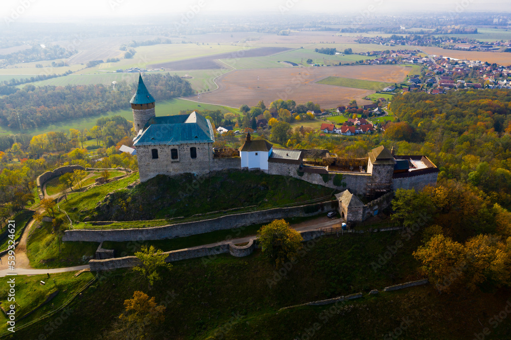 Picturesque autumn landscape with imposing historic Kuneticka Hora Castle on hilltop above Czech village of Raby, Pardubice Region