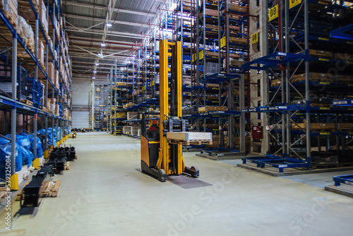 Moving forklift loader in modern warehouse, motion blur