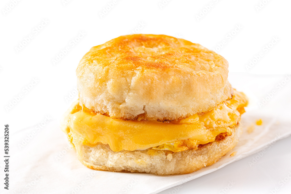 Breakfast egg and cheese sandwich on a white background with copy space
