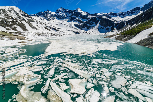 Alpine emerald lake melting and mountains at springtime, Gran Paradiso , Italy