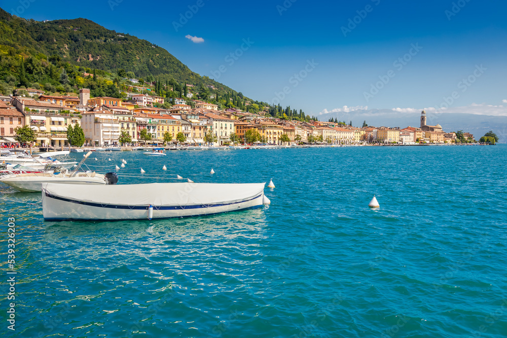 Idyllic lake Garda coastline and mediterranean village with sailboats, Italy