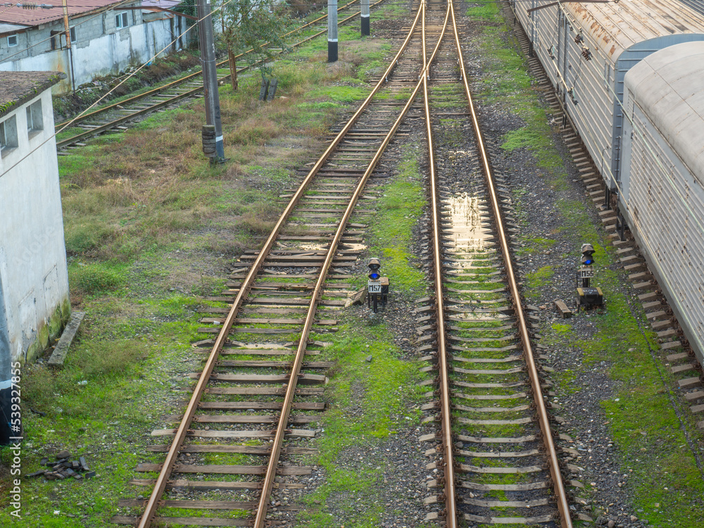 Rails with sleepers on top. Puddles between the rails. Abandoned place. Old station. Cargo transportation. industrial zone Rails with sleepers on top. Puddles between the rails. Abandoned place. Old station. Cargo transportation. industrial zone