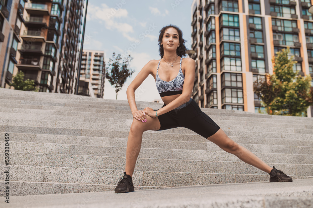 Fototapeta premium Girl in sportsear doing leg lunges and looking involved