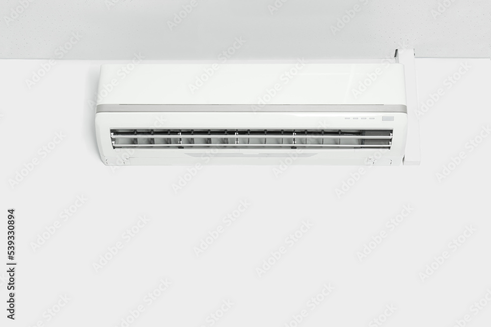 Modern air conditioner on white wall indoors. Space for text Modern air conditioner on white wall indoors. Space for text