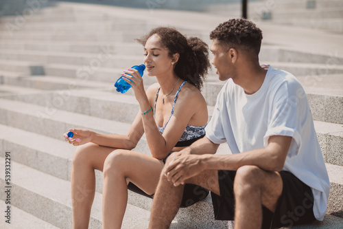 Two young people resting after workout and looking relaxed