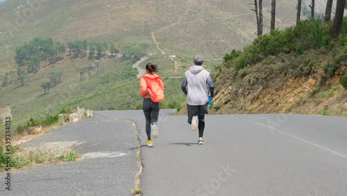 sports couple running on a mountain road early in the morning. Portrait of man and woman couple love are working out training together., Couple fitness and healthy concept. Active couple jogging photo