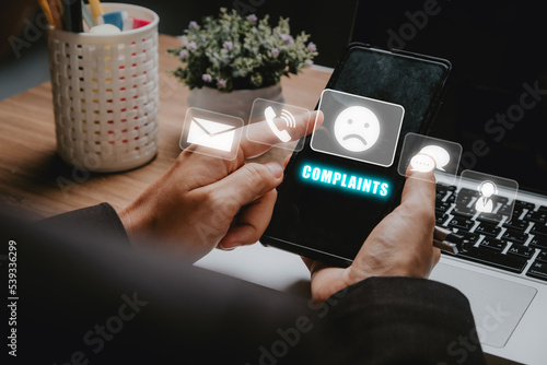 Complaints concept, Business woman using smartphone with complaints icon on vr screen, dissatisfaction from product or service problem, angry feedback from client. photo