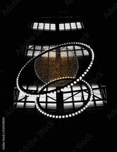 Big circle globe light like earth planet star in space or universe hang on the ceiling with dark background. Textures created from Breathtaking round modern led chandelier, Architecture design decor.