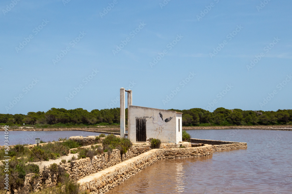 small hut next to a lagoon where sea salt is produced