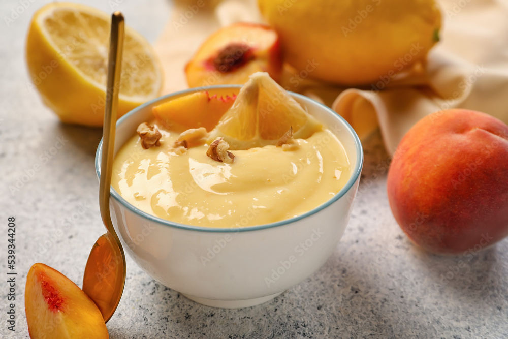 Bowl of delicious vanilla pudding with fruits on light background, closeup