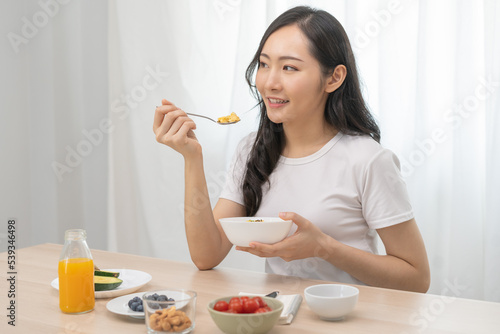 Diet  Dieting asian young woman  girl hand using spoon eating egg salad in a bowl with mix vegetables in plate  keto food is low fat good health. Nutritionist female  Weight loss for healthy person.