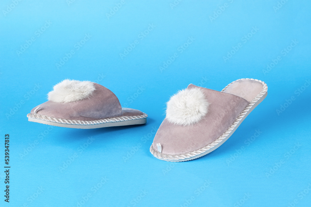 Beige slippers running on a blue background. Beige slippers running on a blue background.
