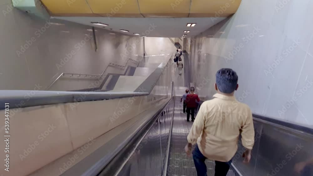 people standing on moving escalator from top angle at morning people standing on moving escalator from top angle at morning