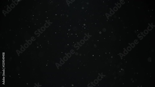 Real dust particles floating in the air on black background. Slow motion. 
