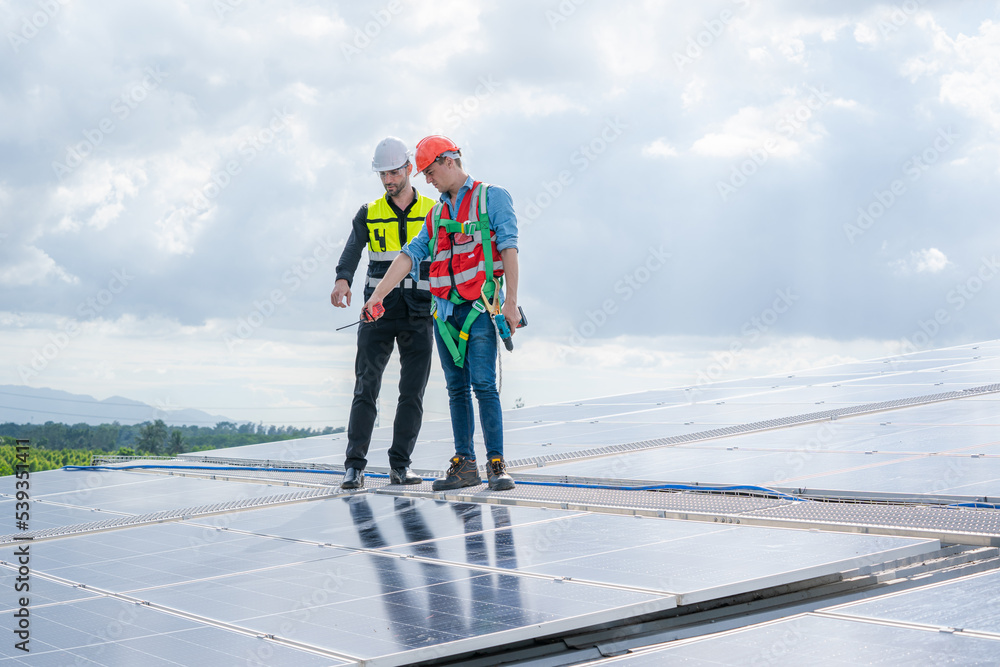 Engineer or worker installing a solar cell on the roof in warehouse factory,Eco technology for electric power. Engineer or worker installing a solar cell on the roof in warehouse factory,Eco technology for electric power.