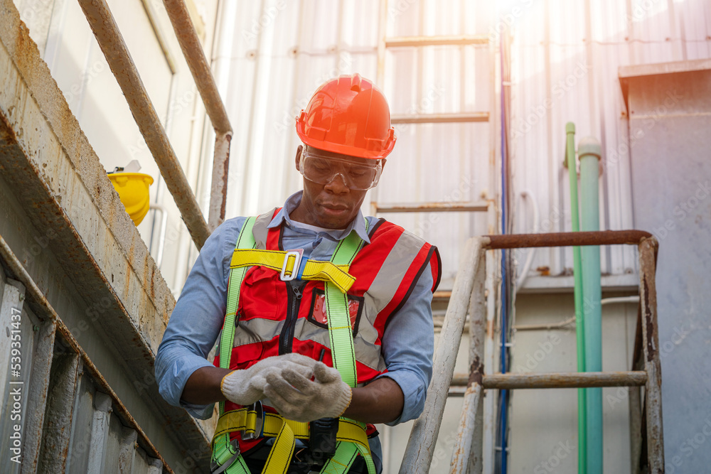 Construction worker wearing safety harness and safety line working at