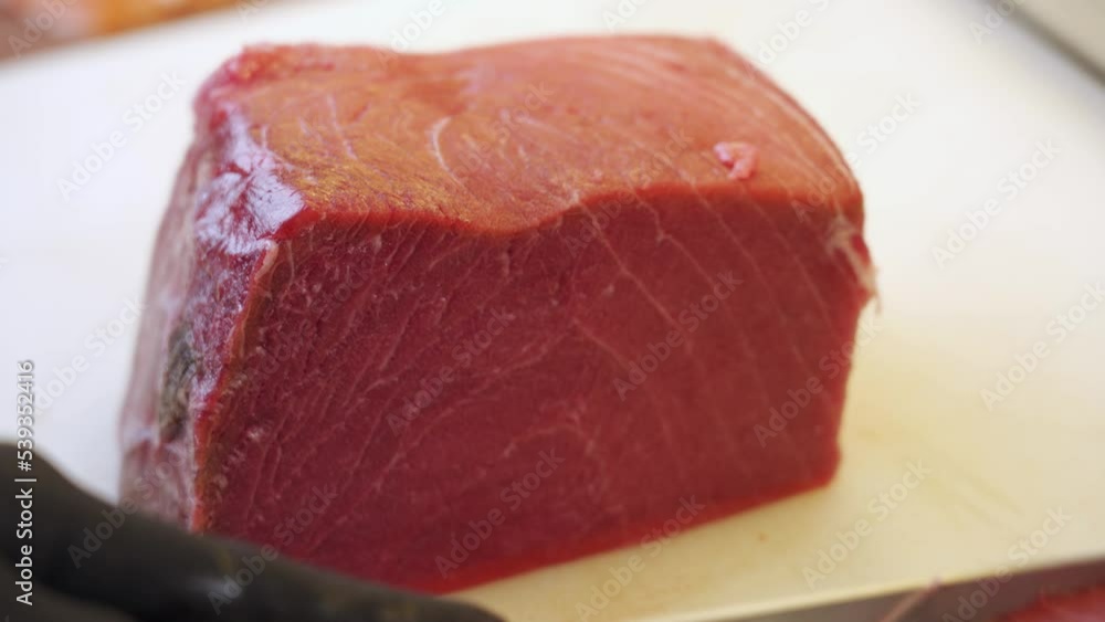 Cutting big tuna flank pieces for sushi, nigiri, and sashimi food sushi restaurant. Cutting big tuna flank pieces for sushi, nigiri, and sashimi food sushi restaurant.