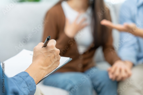 Psychologist records treatment and therapy of couple lost baby in psychiatric hospital. Couples hold hands to support each other while discussing family issues with a psychiatrist. save divorce