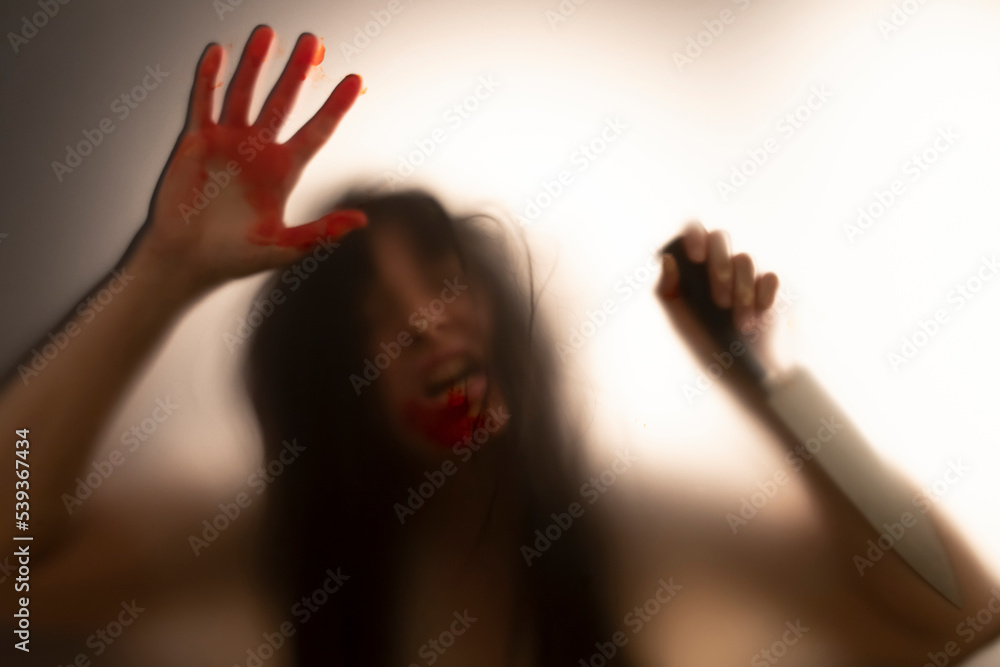 Woman killer with a knife in her hand. Creepy background