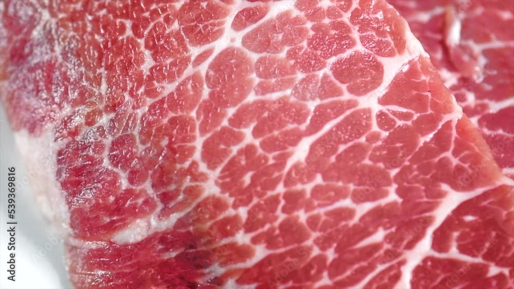 Raw meat, marble beef steak isolated on white background. Prime fillet meat. Black Angus Steak Rib eye texture. Spices. Slow motion Raw meat, marble beef steak isolated on white background. Prime fillet meat. Black Angus Steak Rib eye texture. Spices. Slow motion