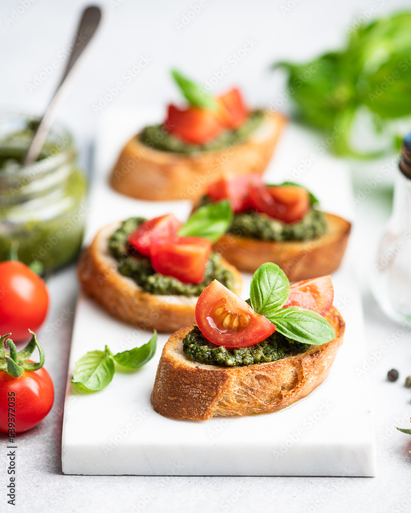 Pesto bruschetta with cherry tomatoes and basil Pesto bruschetta with cherry tomatoes and basil
