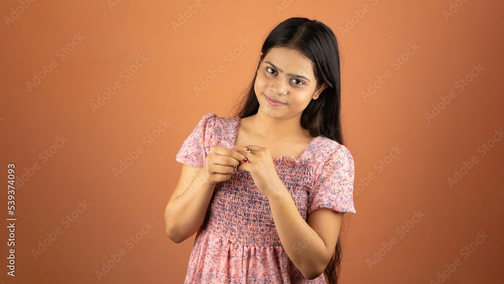 Beautiful excited young Indian woman wearing dress standing isolated over color background, engagement ring on her finger Beautiful excited young Indian woman wearing dress standing isolated over color background, engagement ring on her finger