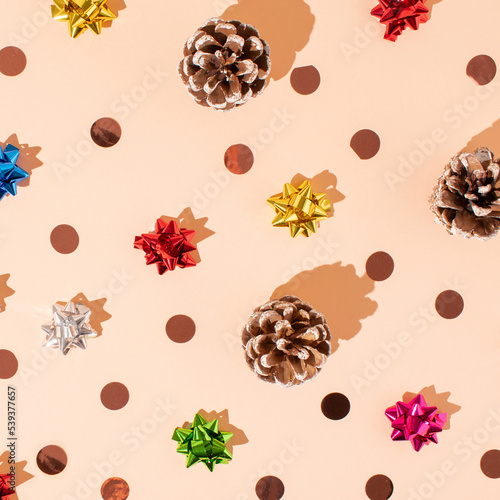 Creative layout made of pine cones and sparkle bow ties on pastel background. Minimal Christmas decorative concept. Winter holiday idea.