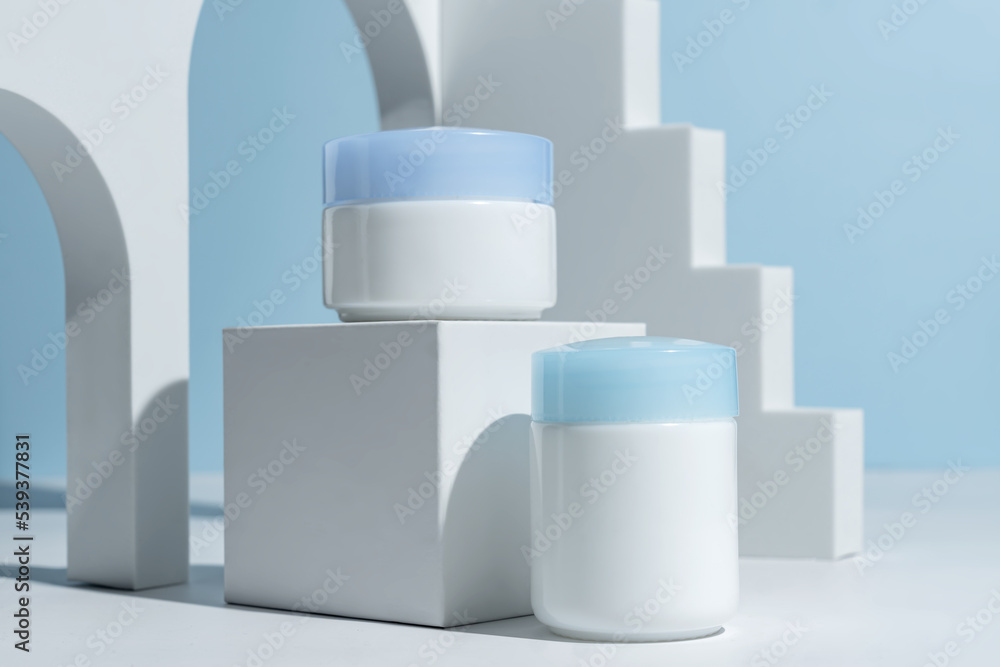 Set of natural cosmetics for face care day and night cream on blue background decorated trendy podium and arch. Skin care cosmetics presentation. Mockup Set of natural cosmetics for face care day and night cream on blue background decorated trendy podium and arch. Skin care cosmetics presentation. Mockup
