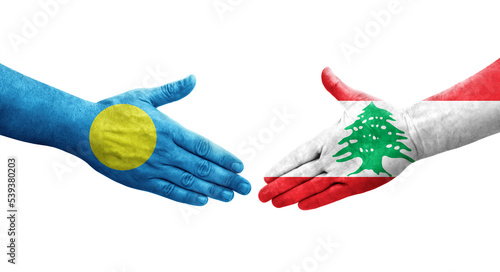 Handshake between Lebanon and Palau flags painted on hands, isolated transparent image.
