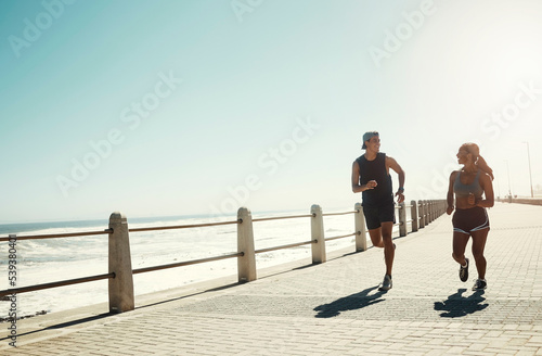Fitness, couple and running for exercise by beach in workout, training and cardio in South Africa outdoors. Active man and woman in sports run by the ocean in sea point for healthy exercising outside