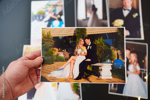 printed wedding photos on a black background and in hand.