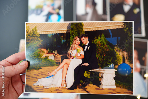 printed wedding photos on a black background and in hand.