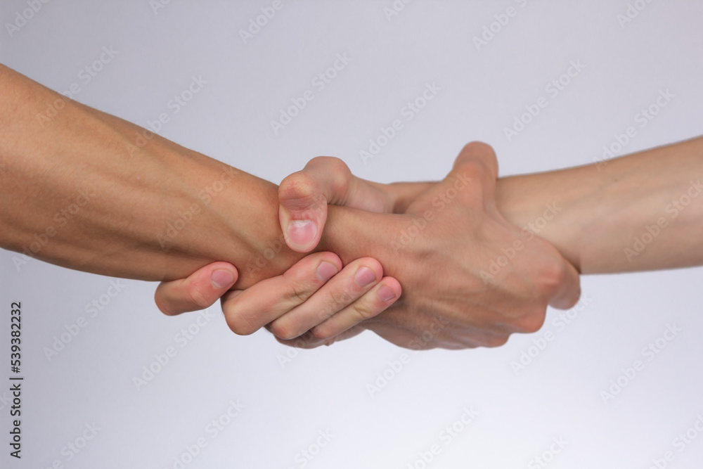 strong male handshake with bare hands on a white background strong male handshake with bare hands on a white background