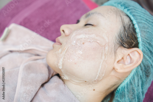 White Asian woman with eyes closed To apply a clear gel on the face, to do facial treatments, in beauty clinics.