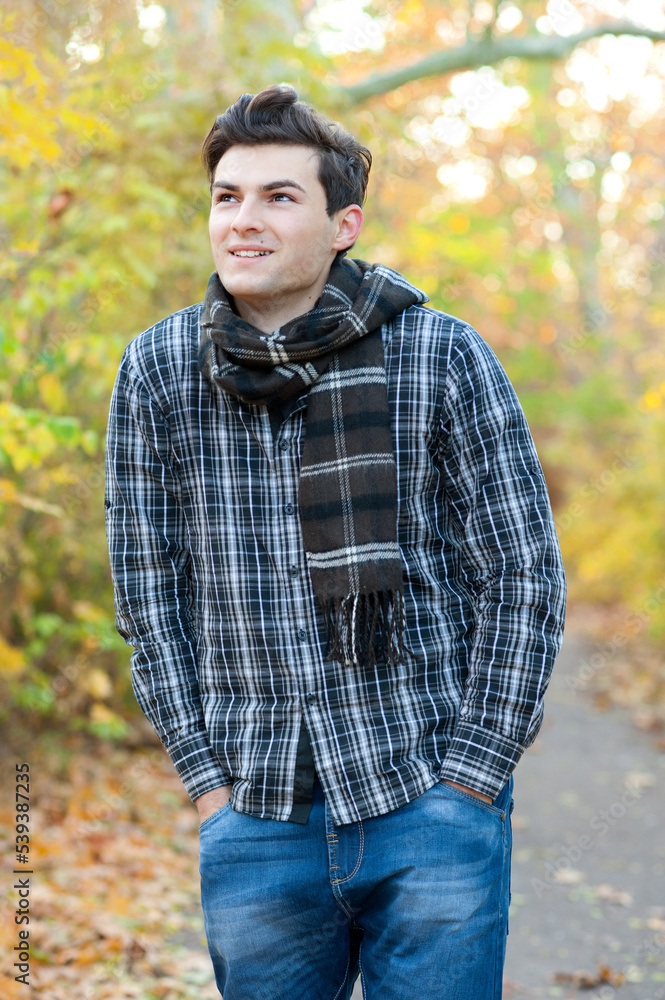 Handsome teenage man walking in autumn park Handsome teenage man walking in autumn park