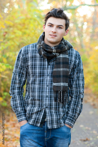 Young handsome teenage man walking in autumn park © LP Design