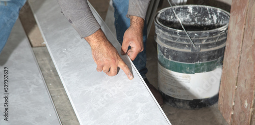 Worker holding plastic panel. Renovating the ceiling