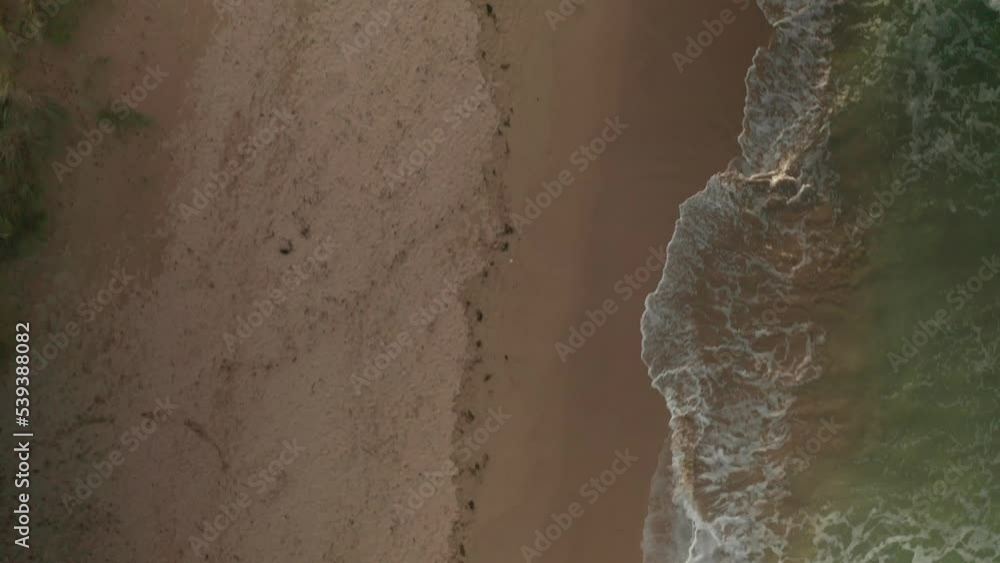 Aerial view of waves breaking on the beach in Cornwall, United Kingdom.