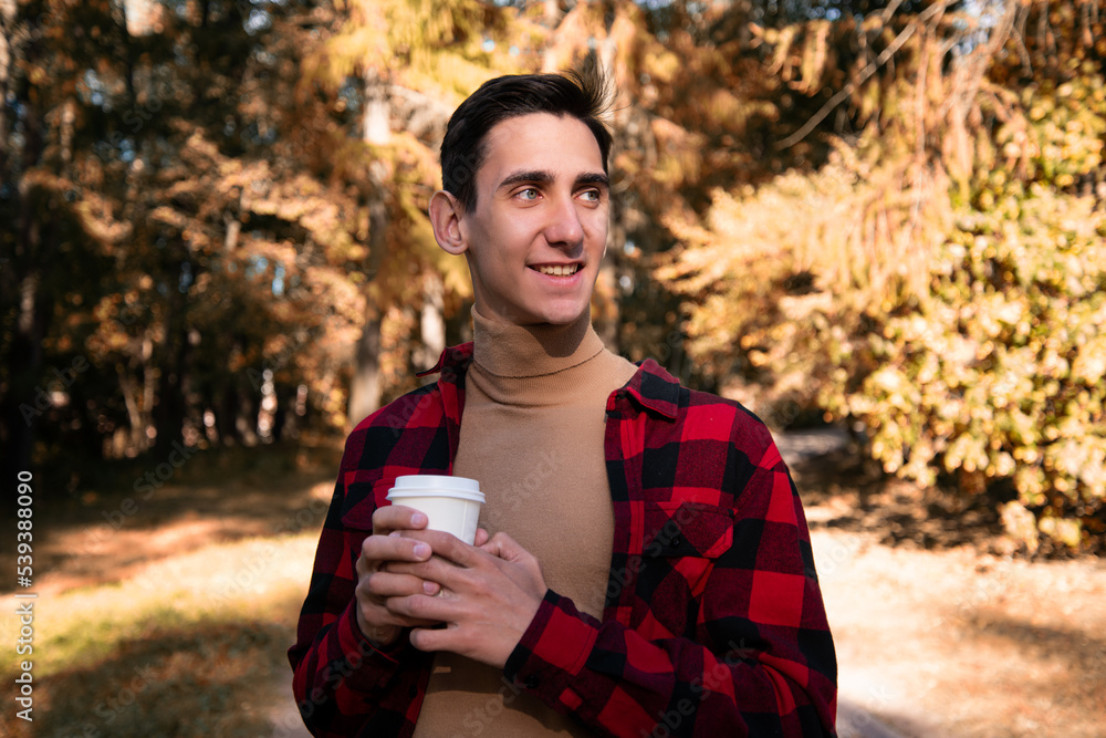 Young attractive guy drinks coffee on the street. Young attractive guy drinks coffee on the street.