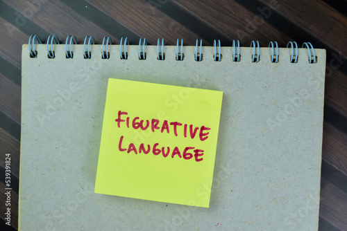 Concept of Figurative Language write on sticky notes isolated on Wooden Table.
