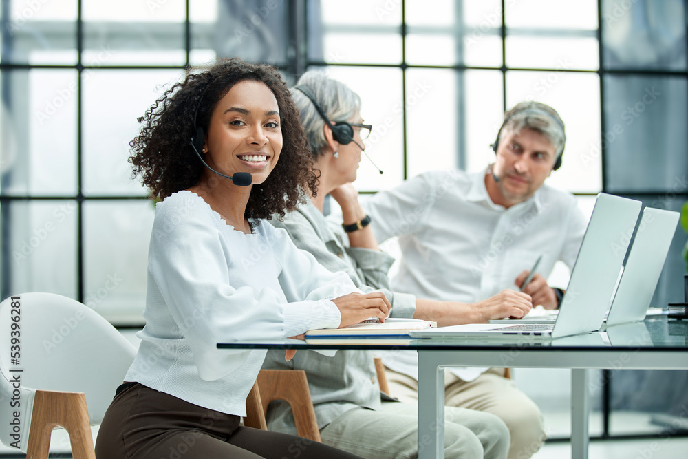 female call center worker accompanied by her team working in the office. female call center worker accompanied by her team working in the office.