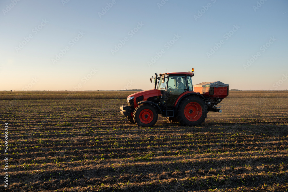 Obraz premium Tractor spreading artificial fertilizers