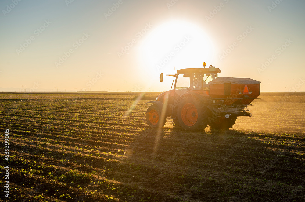 Fototapeta premium Tractor spreading artificial fertilizers