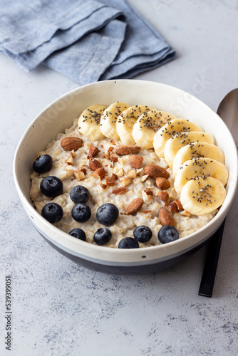 Oatmeal with banana, blueberries, almonds and honey. Healthy food. Vegetarian food. Breakfast.