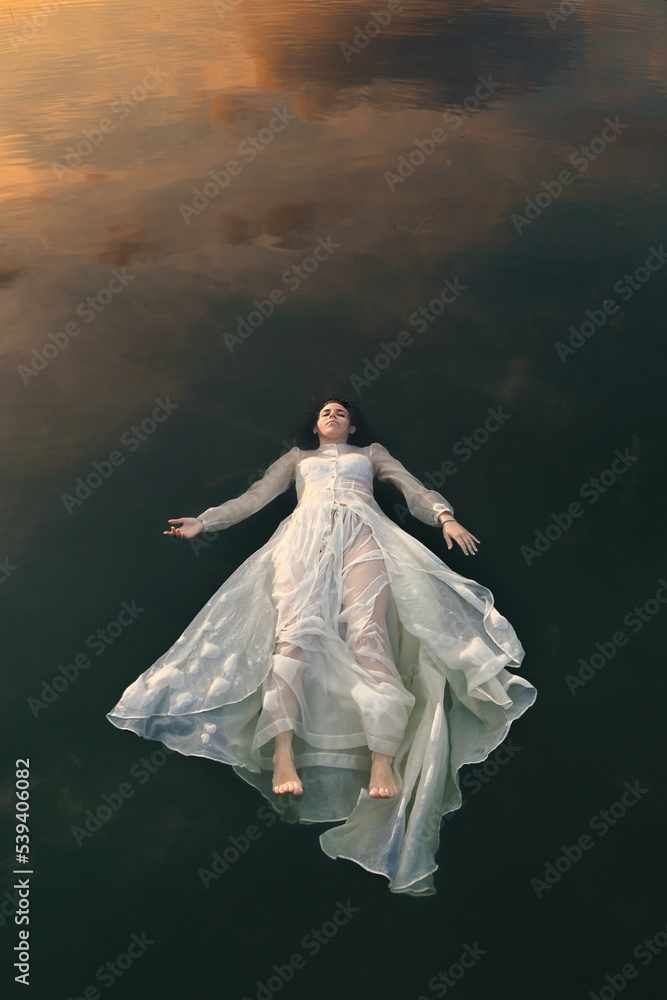 Sleeping woman floating in lake waters Sleeping woman floating in lake waters