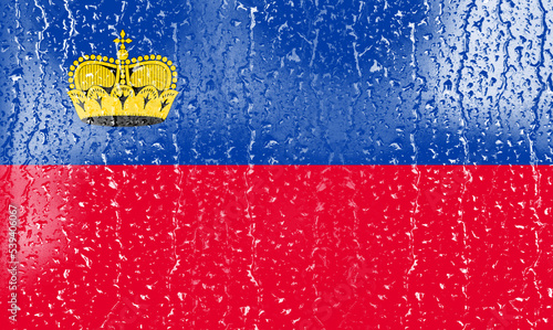 3D Flag of Liechtenstein on a glass with water drop background. © dsom