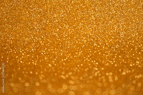 Abstract Glitter Background. Golden Texture Sparkling Shiny Paper for Christmas Holiday. Seasonal Wallpaper Decoration. Greeting and Wedding Invitation Card Design. Sparkle Lights and Bokeh Backdrop.