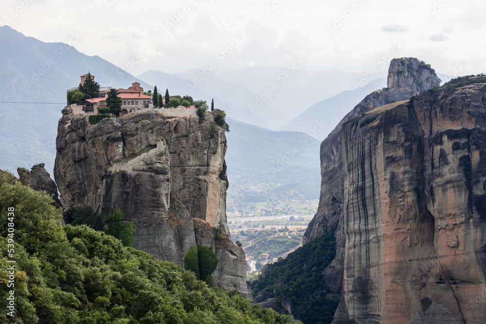 The area around The Monastery of the Holy Trinity is hilly and forested, with Pineios river in  Plain of Thessaly, and a protected area known as Trikala Aesthetic Forest, Meteora, Greece