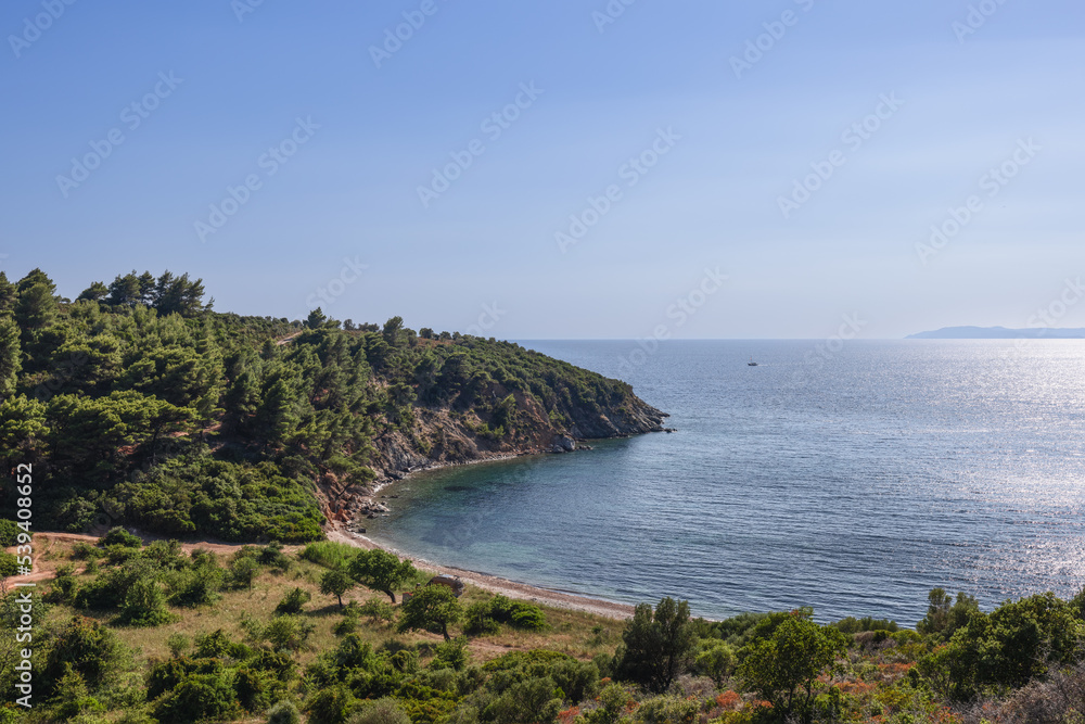 Narrow path leads along slopes of green hill to tiny beach and bay, hidden behind steep, where you can enjoy complete solitude in bosom of mother nature, Sithonia, Chalkidiki, Northern Greece